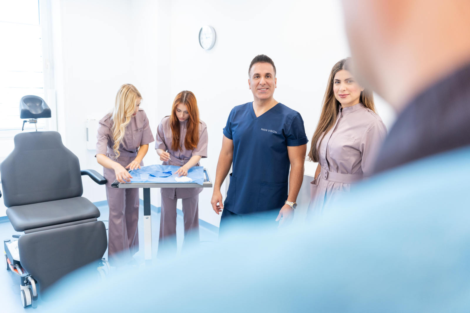 Oberlidstraffung bei MAIN VISION in Frankfurt - Augenarzt Parviz Rafiezadeh und sein Team im OP mit Patient im Vordergrund